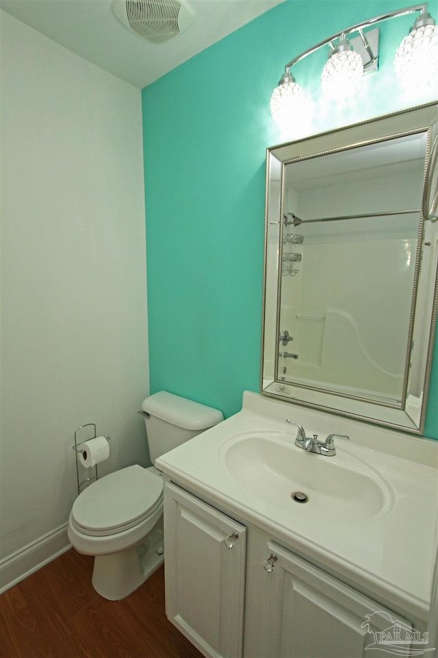 bathroom with toilet, hardwood / wood-style floors, and vanity