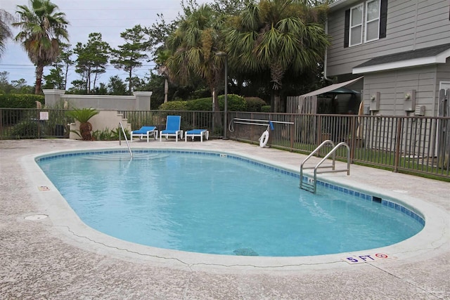 community pool featuring a patio area and fence