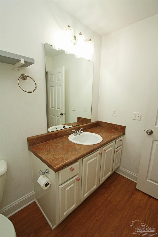 bathroom featuring hardwood / wood-style flooring, toilet, and vanity