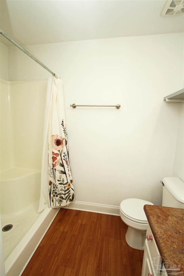 bathroom featuring vanity, toilet, walk in shower, and hardwood / wood-style floors