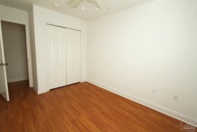 unfurnished bedroom featuring a closet, wood-type flooring, and ceiling fan