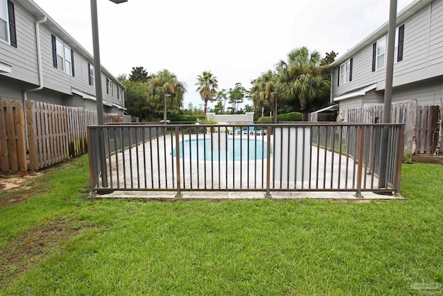 view of swimming pool featuring a fenced in pool, a lawn, and a fenced backyard