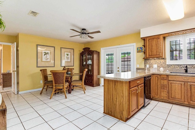 kitchen featuring backsplash, kitchen peninsula, dishwasher, ceiling fan, and sink