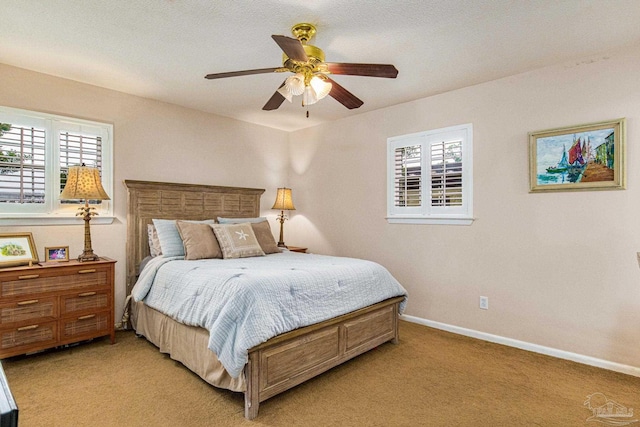 bedroom featuring multiple windows, light colored carpet, and ceiling fan