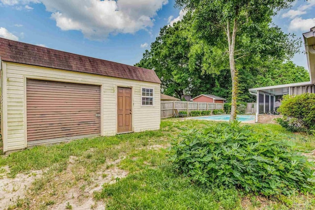 view of yard featuring a fenced in pool and an outbuilding