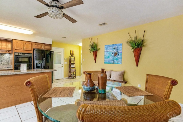 tiled dining room featuring ceiling fan and a textured ceiling