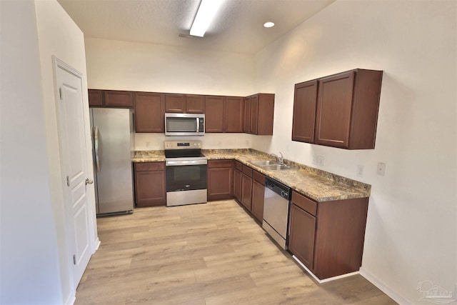 2608 Salamanca St, Navarre, FL 32566 - kitchen featuring stainless steel appliances, a sink, a towering ceiling, light wood-type flooring, and baseboards