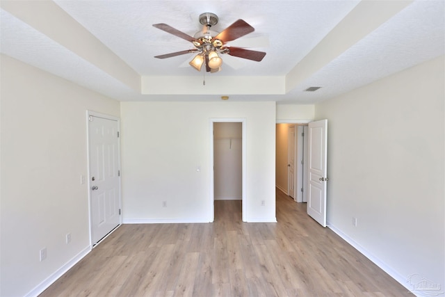 2608 Salamanca St, Navarre, FL 32566 - unfurnished bedroom featuring light wood finished floors, baseboards, a tray ceiling, and ceiling fan