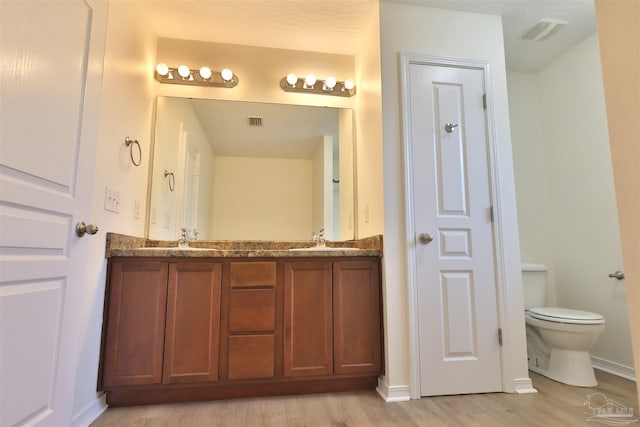 2608 Salamanca St, Navarre, FL 32566 - full bathroom with double vanity, wood finished floors, toilet, and baseboards