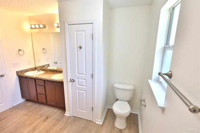 2608 Salamanca St, Navarre, FL 32566 - full bathroom featuring wood finished floors, toilet, double vanity, and baseboards