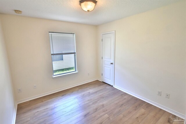 2608 Salamanca St, Navarre, FL 32566 - empty room with a smoke detector, wood finished floors, and baseboards