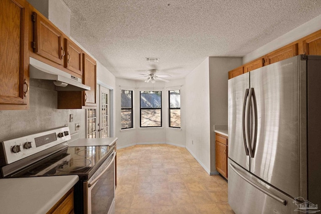 kitchen with a textured ceiling, ceiling fan, and appliances with stainless steel finishes