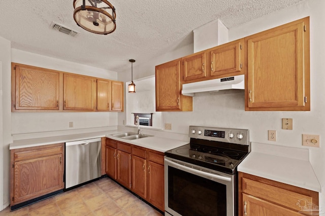 kitchen with sink, hanging light fixtures, appliances with stainless steel finishes, and a textured ceiling