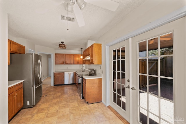 kitchen featuring ceiling fan, french doors, sink, a textured ceiling, and stainless steel appliances