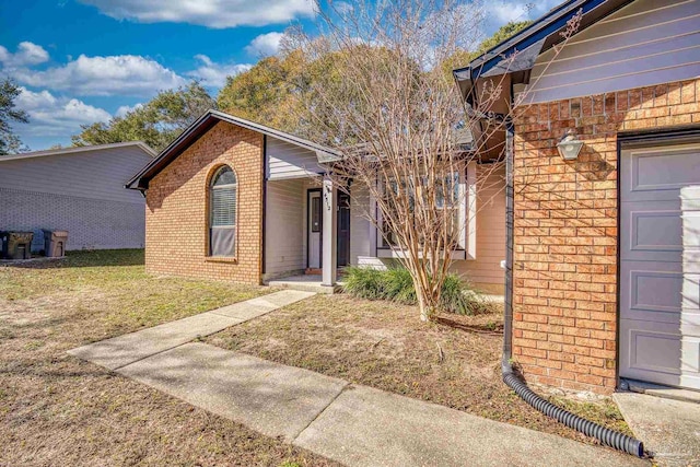 property entrance featuring a garage and a yard