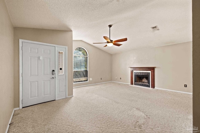 unfurnished living room with ceiling fan, carpet, a textured ceiling, and lofted ceiling