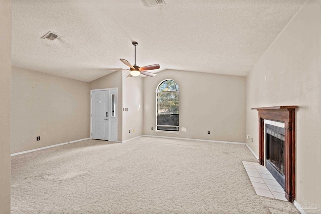 unfurnished living room with vaulted ceiling, ceiling fan, light colored carpet, and a tiled fireplace