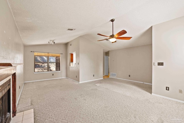 unfurnished living room with light carpet, a tile fireplace, and vaulted ceiling