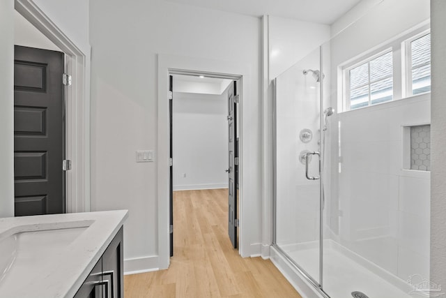 bathroom with wood-type flooring, an enclosed shower, and vanity