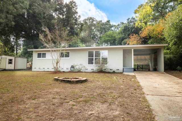 single story home with a shed, a front yard, and a carport