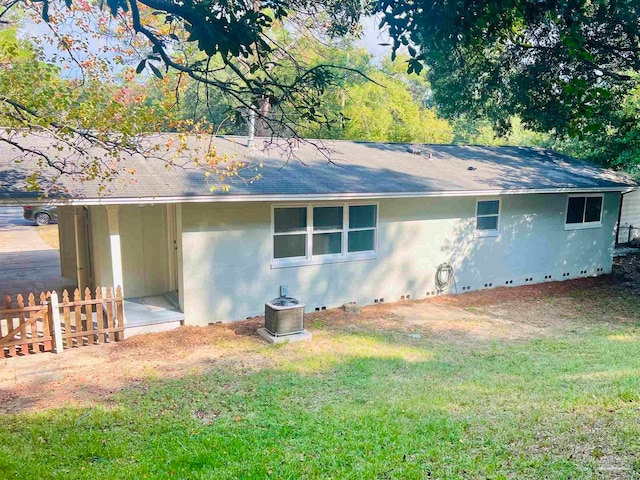 back of house featuring a lawn and central AC