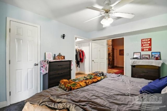 2738 Garcon Point Rd, Milton, FL 32583 - bedroom featuring a closet, a ceiling fan, a walk in closet, and baseboards