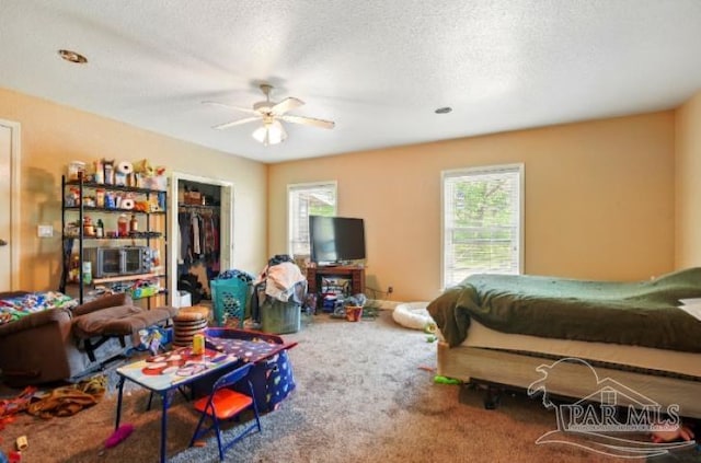 2738 Garcon Point Rd, Milton, FL 32583 - bedroom featuring a textured ceiling, carpet, a spacious closet, ceiling fan, and a closet