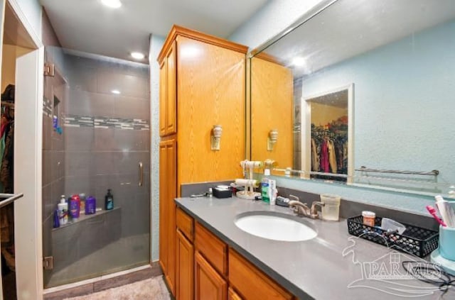 2738 Garcon Point Rd, Milton, FL 32583 - bathroom featuring vanity, a spacious closet, a shower stall, and recessed lighting