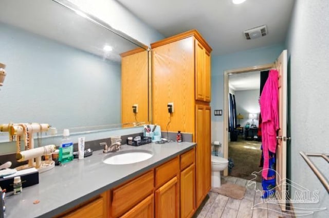 2738 Garcon Point Rd, Milton, FL 32583 - bathroom featuring toilet, vanity, and wood finished floors