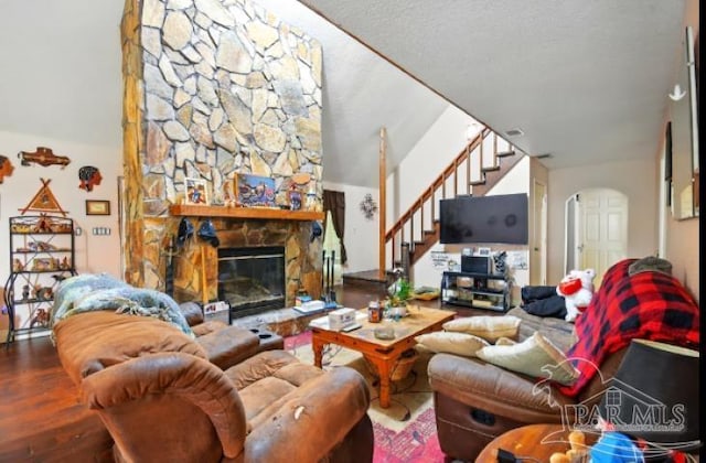 2738 Garcon Point Rd, Milton, FL 32583 - living area featuring stairs, arched walkways, wood finished floors, a fireplace, and vaulted ceiling