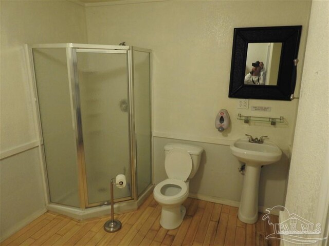 bathroom featuring an enclosed shower, hardwood / wood-style flooring, and toilet