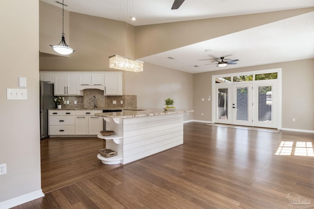 kitchen with a sink, a ceiling fan, white cabinetry, freestanding refrigerator, and open shelves