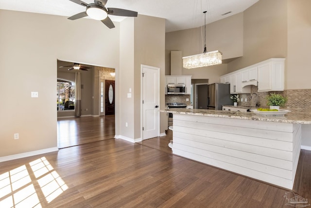 kitchen featuring stainless steel appliances, dark wood-type flooring, a sink, and white cabinets