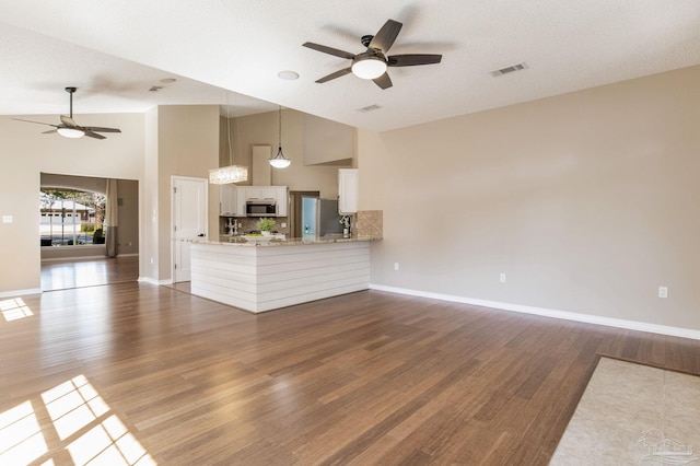 unfurnished living room featuring baseboards, visible vents, ceiling fan, and wood finished floors