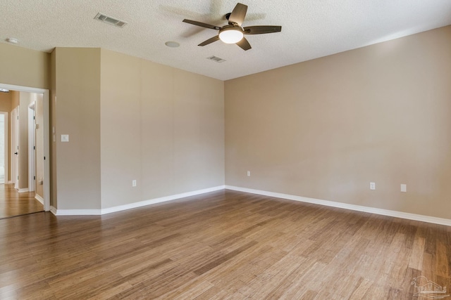 spare room with visible vents, ceiling fan, and wood finished floors