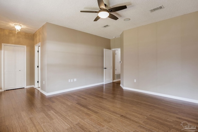 unfurnished room featuring wood finished floors, visible vents, and baseboards