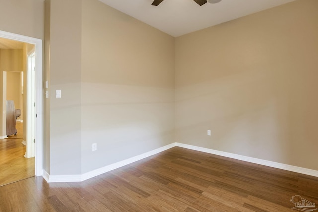 unfurnished room featuring a ceiling fan, baseboards, and wood finished floors