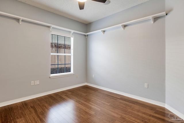 empty room featuring a textured ceiling, wood finished floors, a ceiling fan, and baseboards