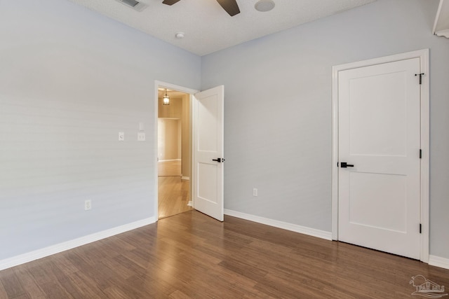 unfurnished bedroom featuring wood finished floors, a ceiling fan, and baseboards