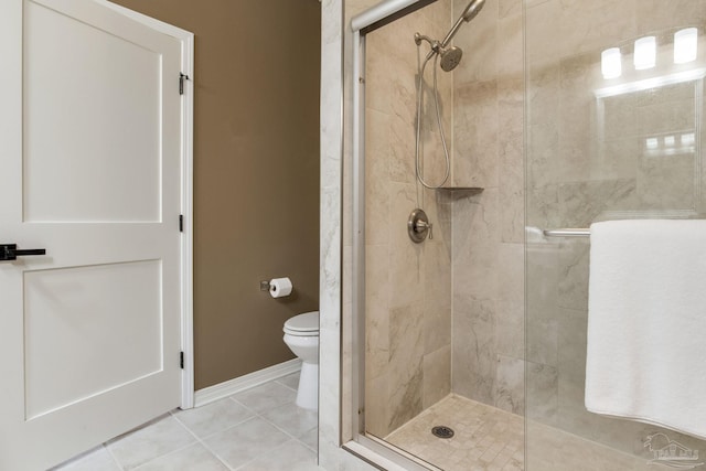 full bath featuring a stall shower, tile patterned flooring, toilet, and baseboards