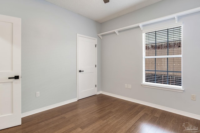 empty room featuring ceiling fan, a textured ceiling, baseboards, and wood finished floors