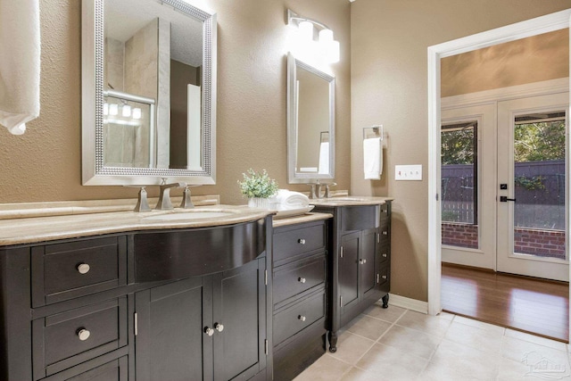 bathroom featuring baseboards, a shower with door, vanity, tile patterned flooring, and french doors