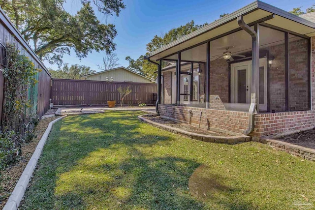 view of yard featuring a sunroom and a fenced backyard