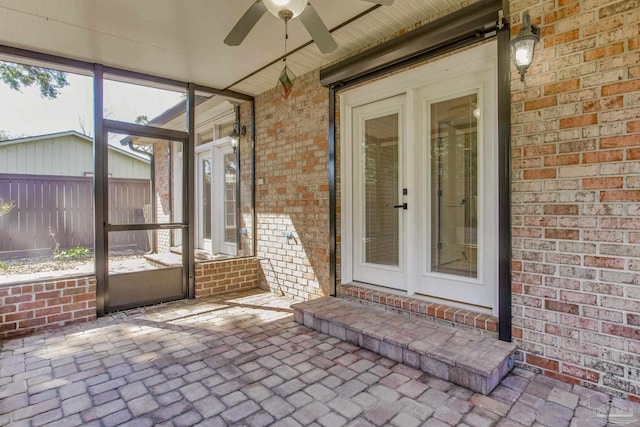 unfurnished sunroom featuring a ceiling fan