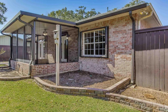 view of home's exterior with a sunroom and brick siding