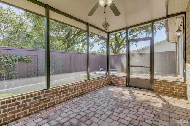 unfurnished sunroom featuring a ceiling fan