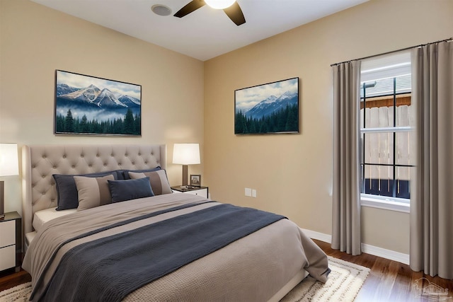 bedroom with ceiling fan, baseboards, and wood finished floors