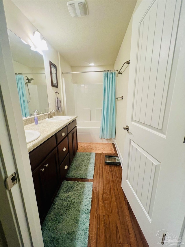 bathroom featuring vanity, wood-type flooring, and shower / tub combo with curtain