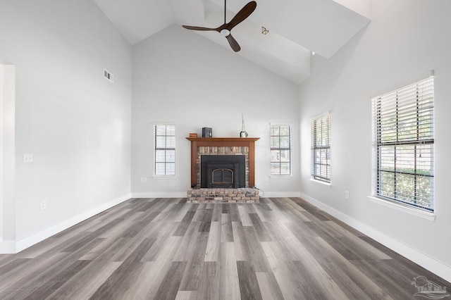 unfurnished living room with ceiling fan, wood-type flooring, and high vaulted ceiling