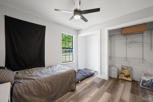 bedroom with ceiling fan, a closet, and wood-type flooring